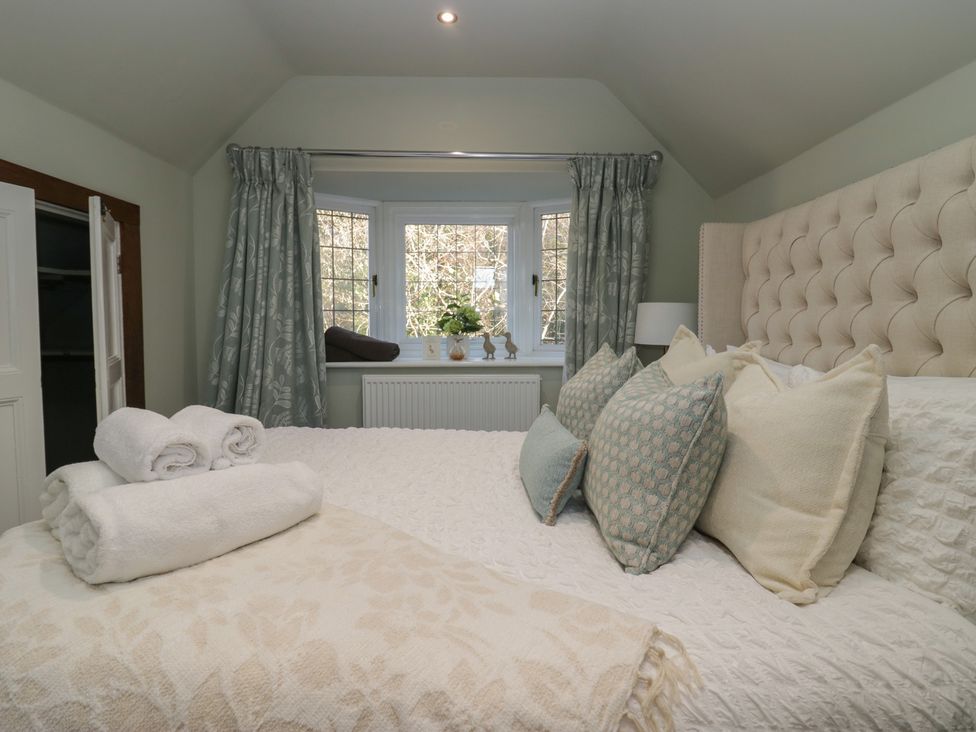 A bedroom with a bed and curtains at North Cottage in Bowness-On-Windermere
