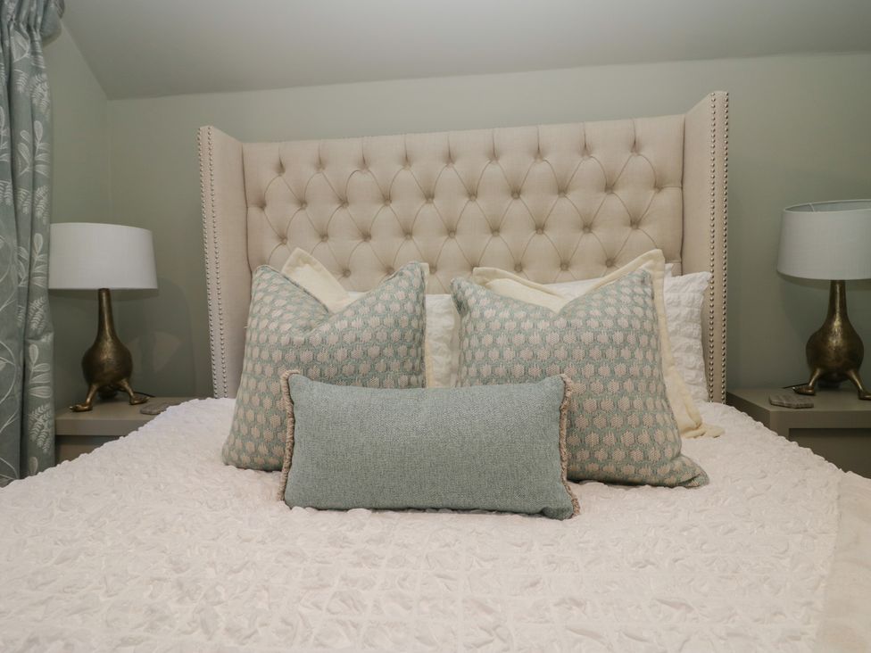 A bedroom with a bed and decorative pillows at North Cottage in Bowness-On-Windermere