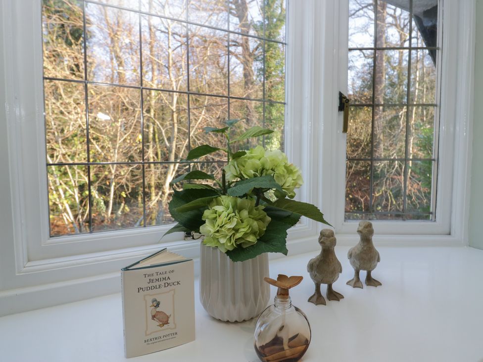 A window with flowers and decorative items at North Cottage in Bowness-On-Windermere