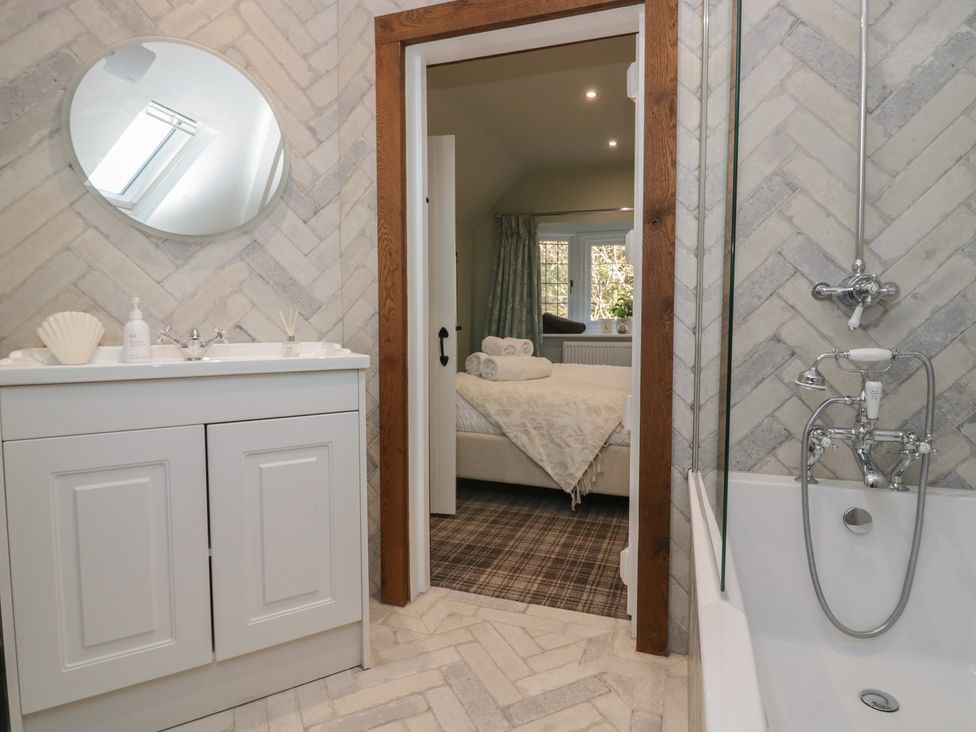 A bathroom with a sink and bathtub at North Cottage in Bowness-On-Windermere
