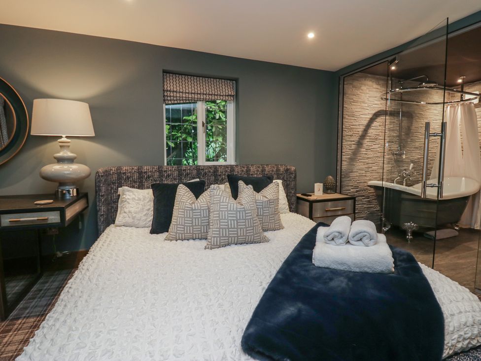 A bedroom with a bed and a bathtub at North Cottage in Bowness-On-Windermere