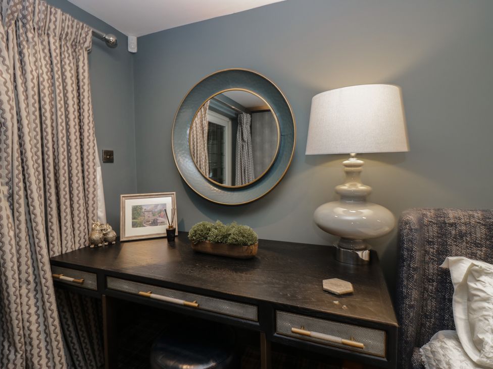 A bedroom with a desk and lamp at North Cottage in Bowness-On-Windermere