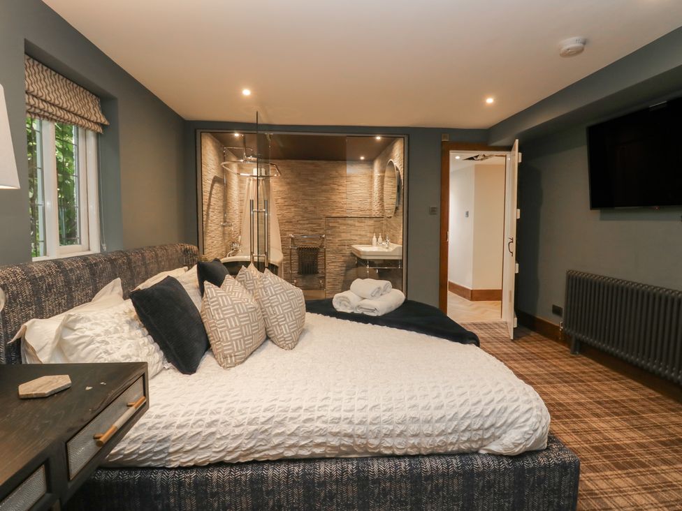 A bedroom with a bed and attached bathroom at North Cottage Bowness-On-Windermere
