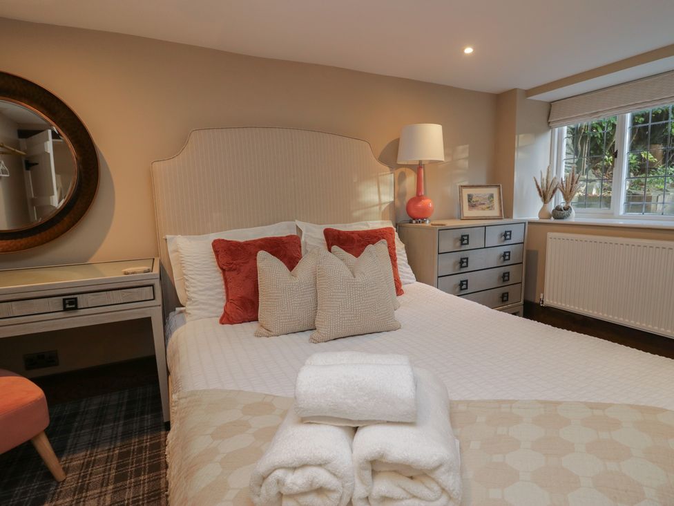 A bedroom with a bed and drawers at North Cottage in Bowness-On-Windermere