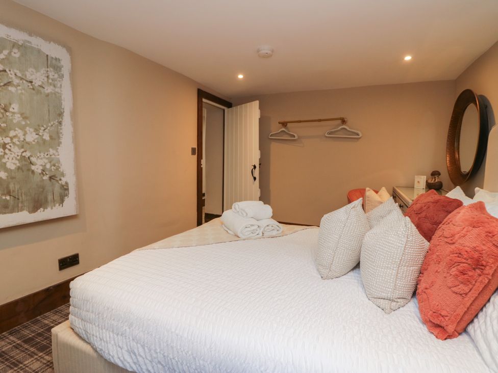 A bedroom with a bed and pillows at North Cottage in Bowness-On-Windermere