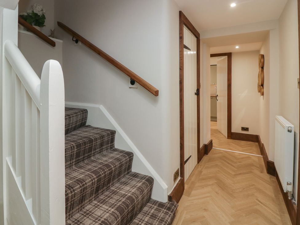 A hallway with stairs and doors at North Cottage Bowness-On-Windermere