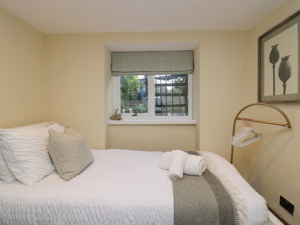 A bedroom with a bed and window at North Cottage in Bowness-On-Windermere