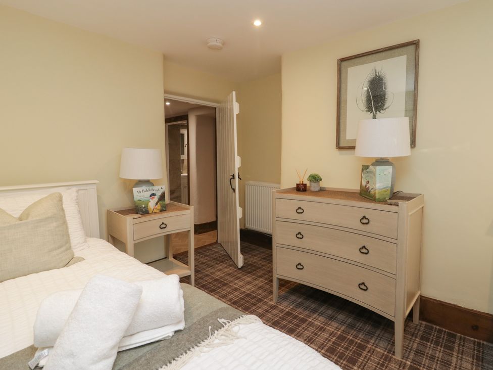A bedroom with a bed and furniture at North Cottage Bowness-On-Windermere
