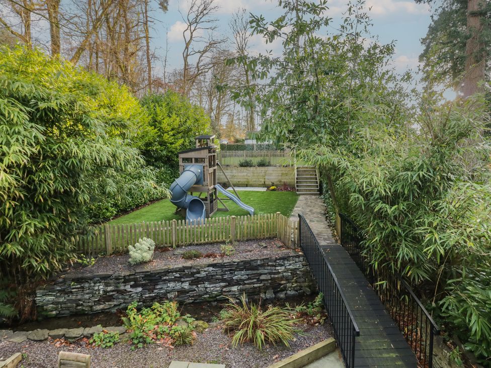 A garden with a playhouse and slide at North Cottage Bowness-On-Windermere