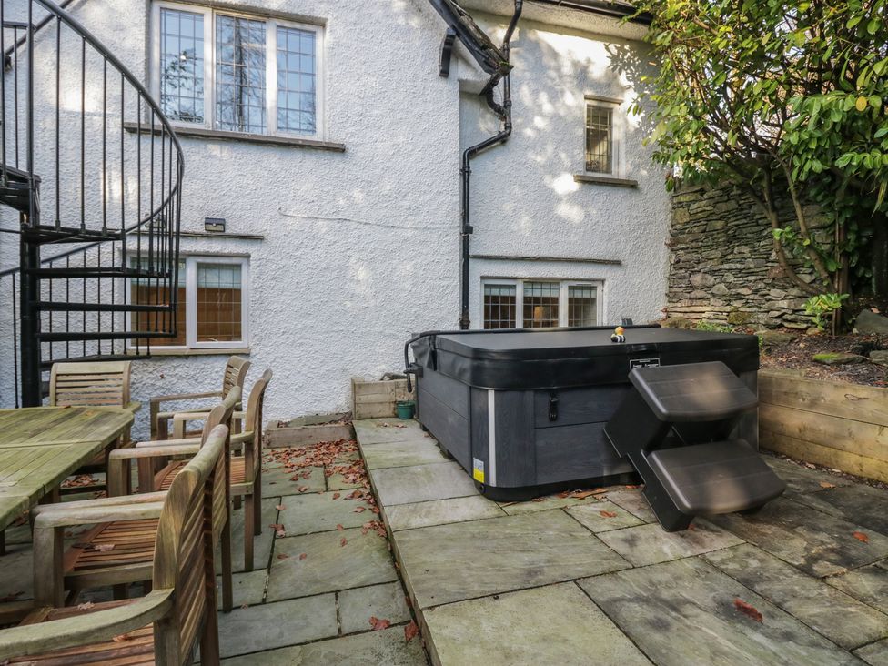 A garden with a hot tub and patio furniture at North Cottage in Bowness-On-Windermere