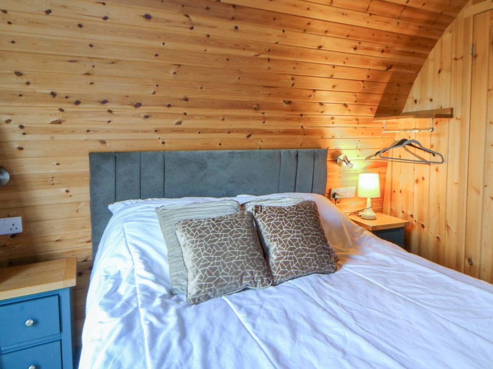 A bedroom with a bed and lamp at Garden Lodge 4 Swansea