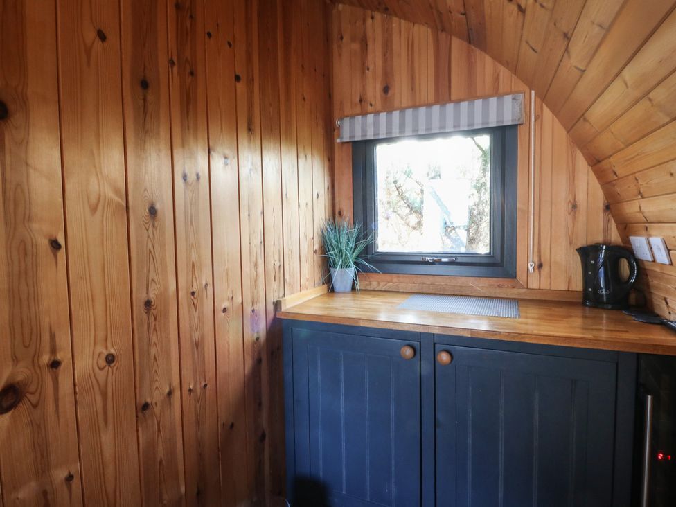 A kitchen with wooden walls and a kettle in Garden Lodge 4 Swansea