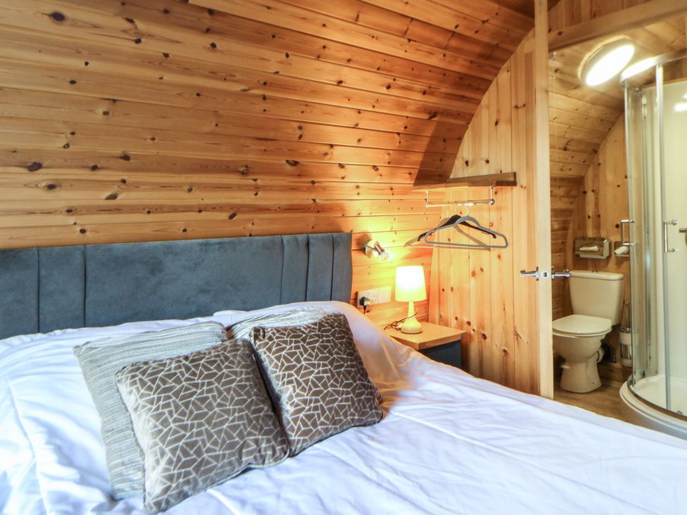 A bedroom with a bed and attached bathroom at Garden Lodge 4 Swansea