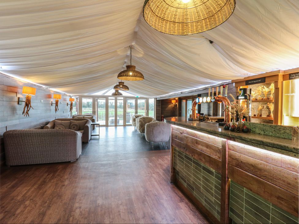 A bar area with sofas and a counter at Garden Lodge 4 Swansea