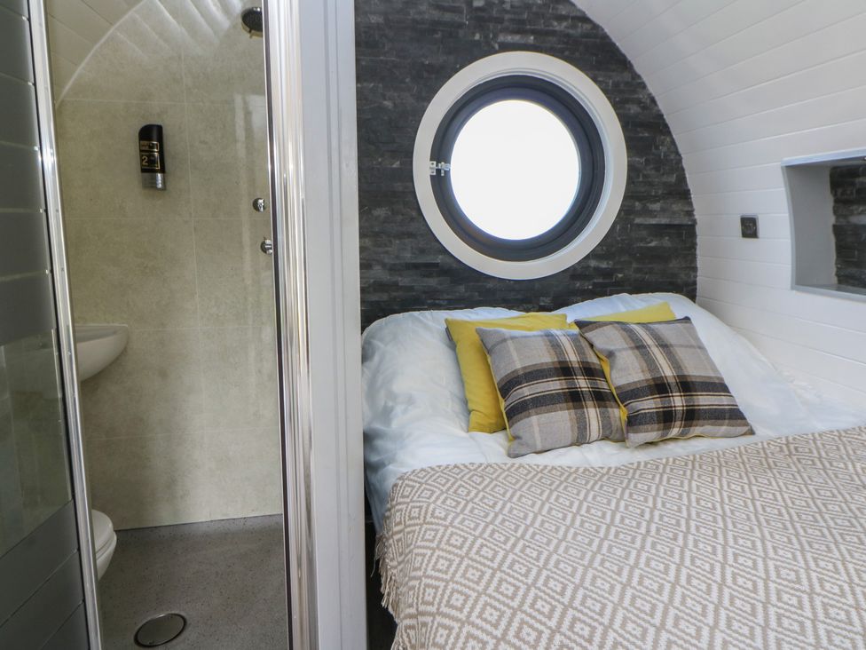 A bedroom with a bed and an adjoining bathroom at Garden Lodge 5 Swansea