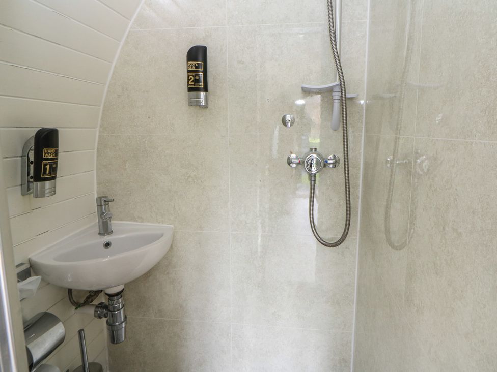 A bathroom with a wash basin and shower fixtures at Garden Lodge 5 Swansea