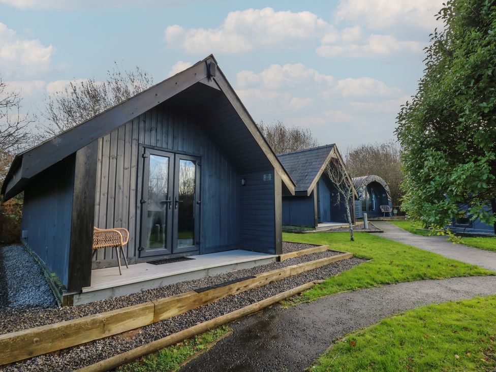 Cabins with porches in a nature setting at Garden Lodge 7 Swansea