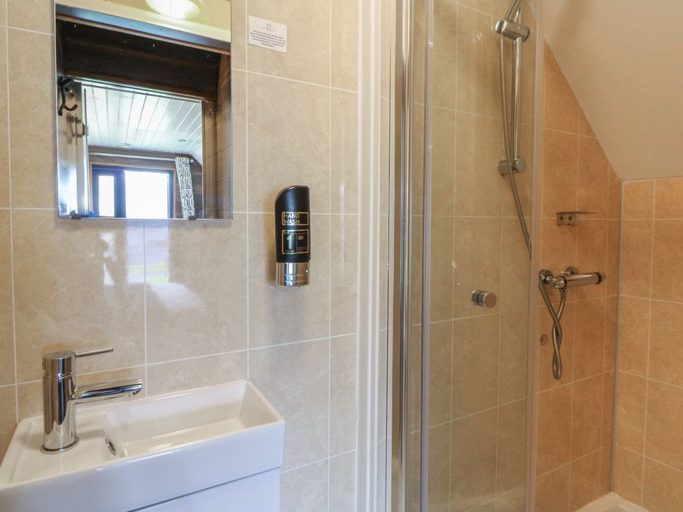 A bathroom with a shower and sink at Garden Lodge 8 in Swansea