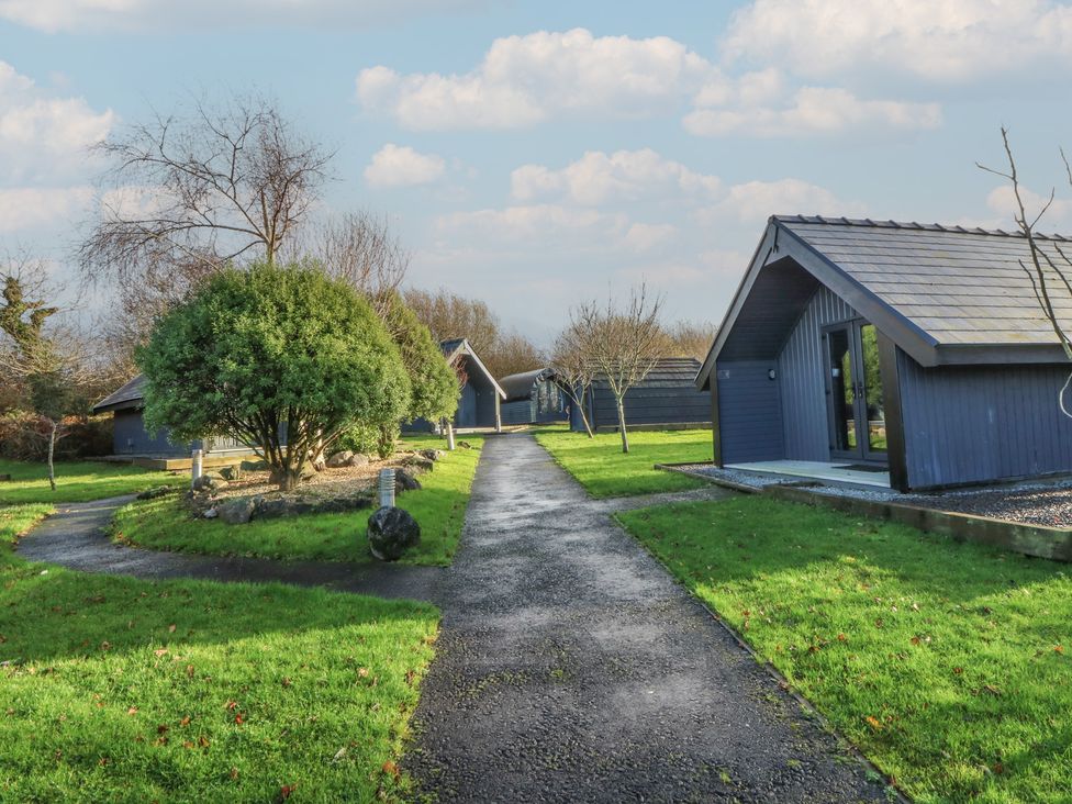 A pathway with cabins and greenery at Garden Lodge 10 in Swansea