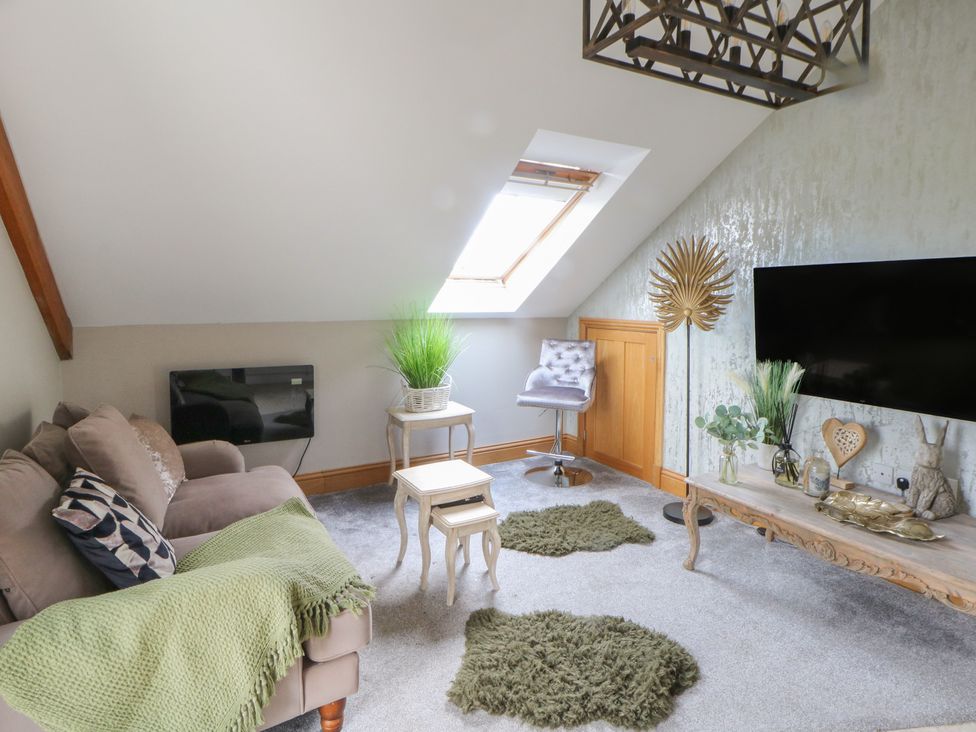 A living room with a sofa and television at Rose Apartment Oldwalls near Reynoldston
