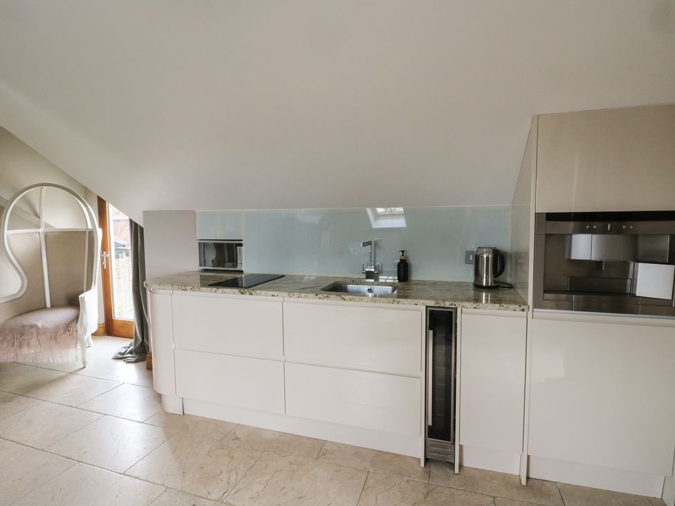 A kitchen with cabinets and appliances at Rose Apartment Oldwalls near Reynoldston