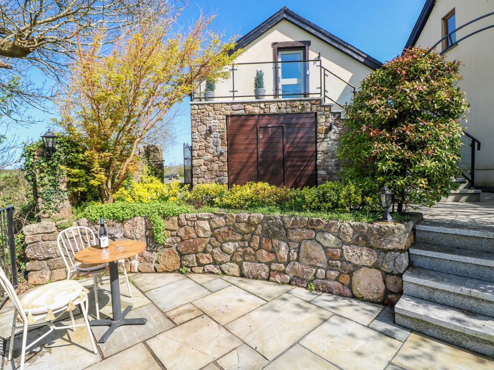 A garden with a table and chair at Rose Apartment, Old Walls, Llanrhidian, Gower
