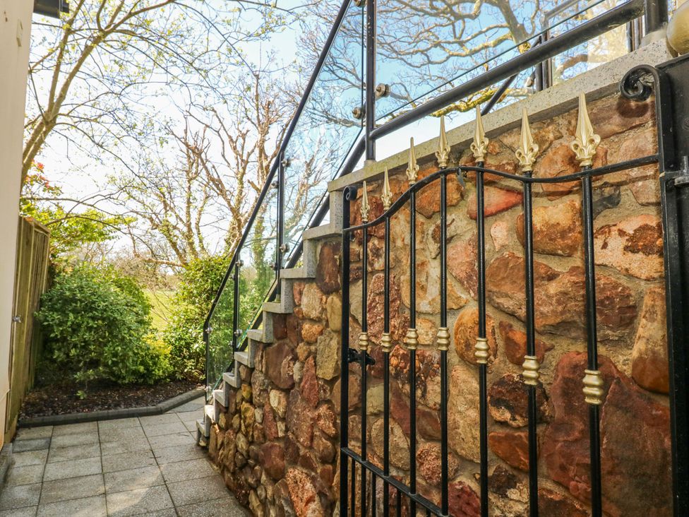A gated entrance with stone wall and steps at Rose Apartment, Old Walls, Llanrhidian, Gower