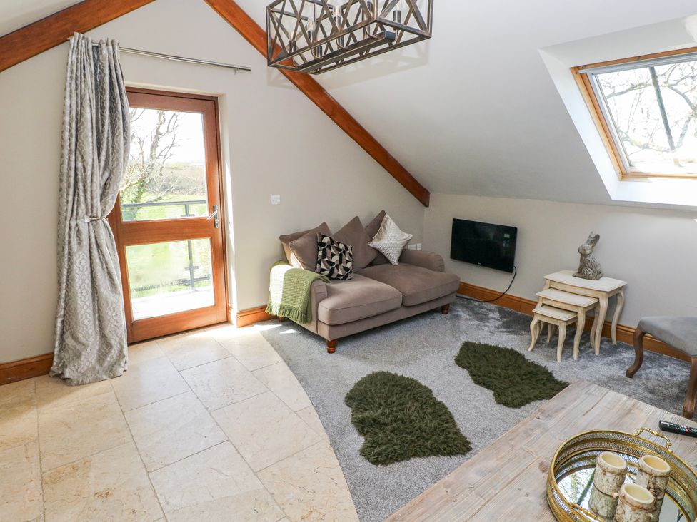 A living room with a sofa and a coffee table at Rose Apartment in Old Walls, Llanrhidian, Gower