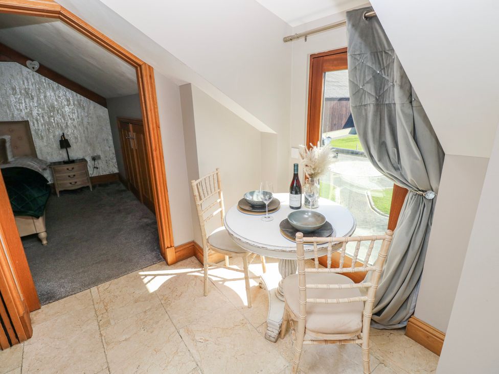 A dining area with a table and chairs at Rose Apartment, Old Walls, Llanrhidian, Gower