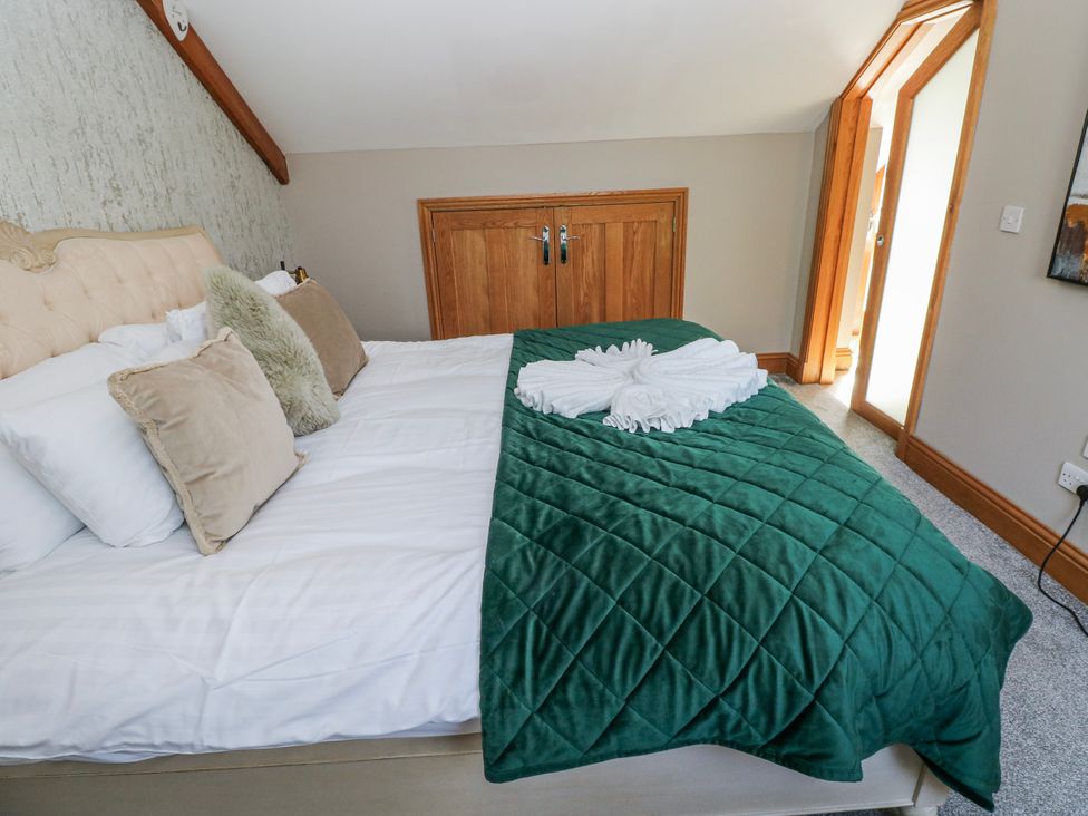 A bedroom with a bed and wardrobe at Rose Apartment in Old Walls, Llanrhidian, Gower