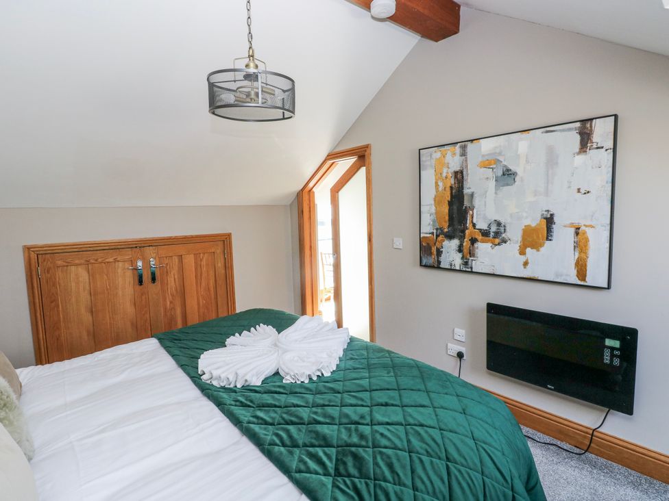 A bedroom with a bed and a door leading outside at Rose Apartment Old Walls, Llanrhidian, Gower