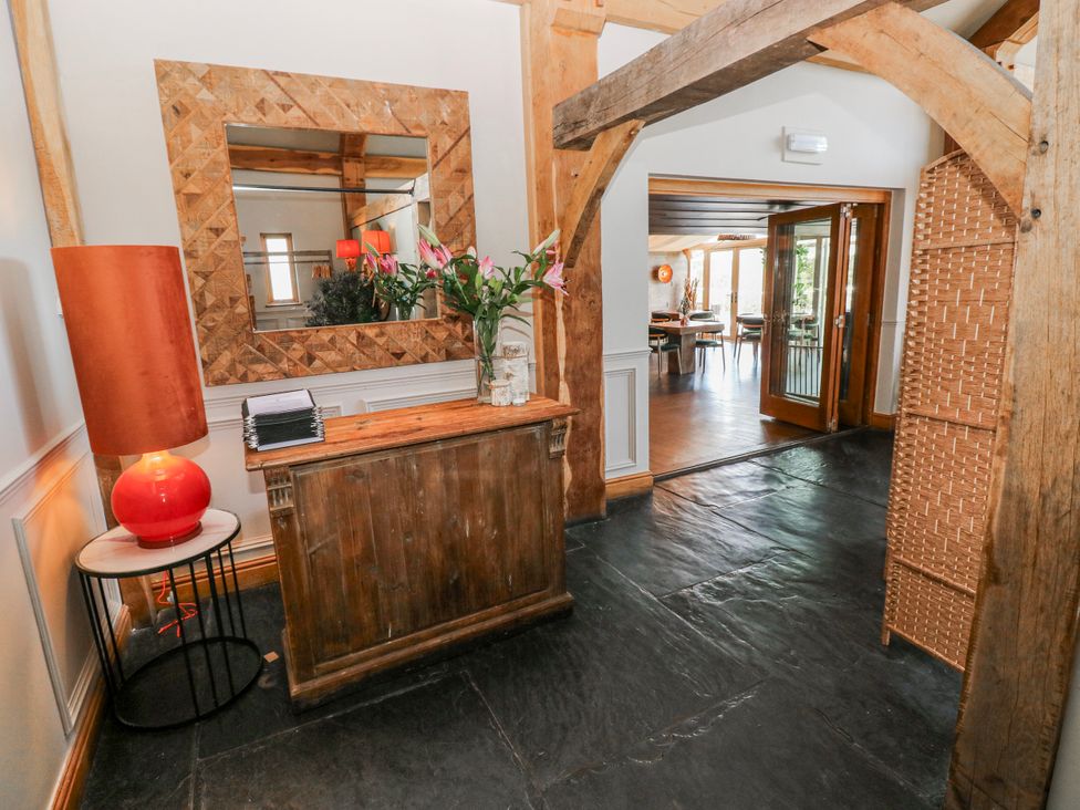 An entryway with a reception desk and a vase of flowers at Rose Apartment Old Walls, Llanrhidian, Gower