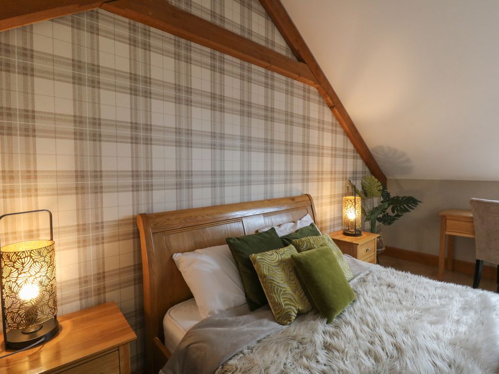 A bedroom with a bed and lamps at Willow Apartment in Swansea