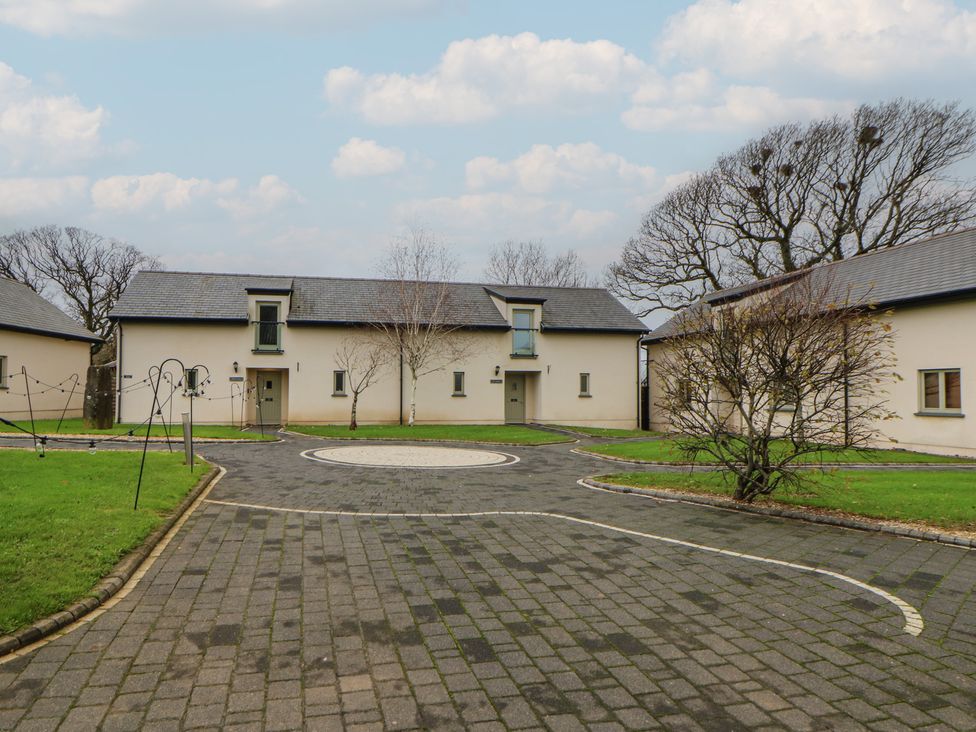 A view of a courtyard with buildings and trees at Willow Apartment in Swansea