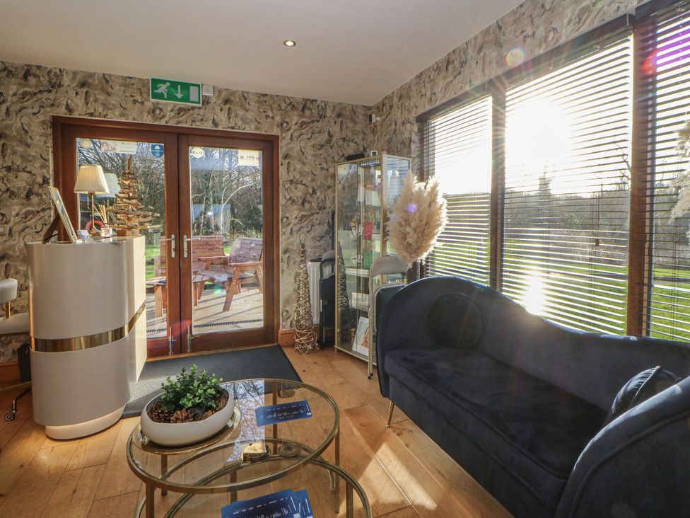 A lobby with a sofa and a glass table at Willow Apartment in Swansea