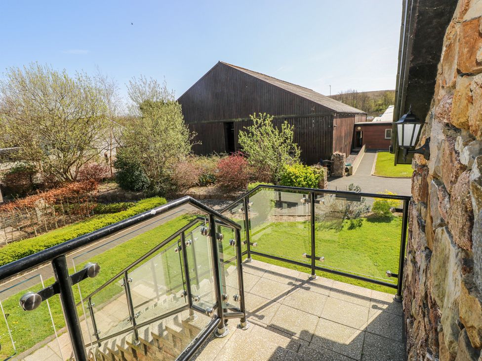 An outdoor area with a balcony overlooking buildings at Willow Apartment in Oldwalls, Llanrhidian, Gower