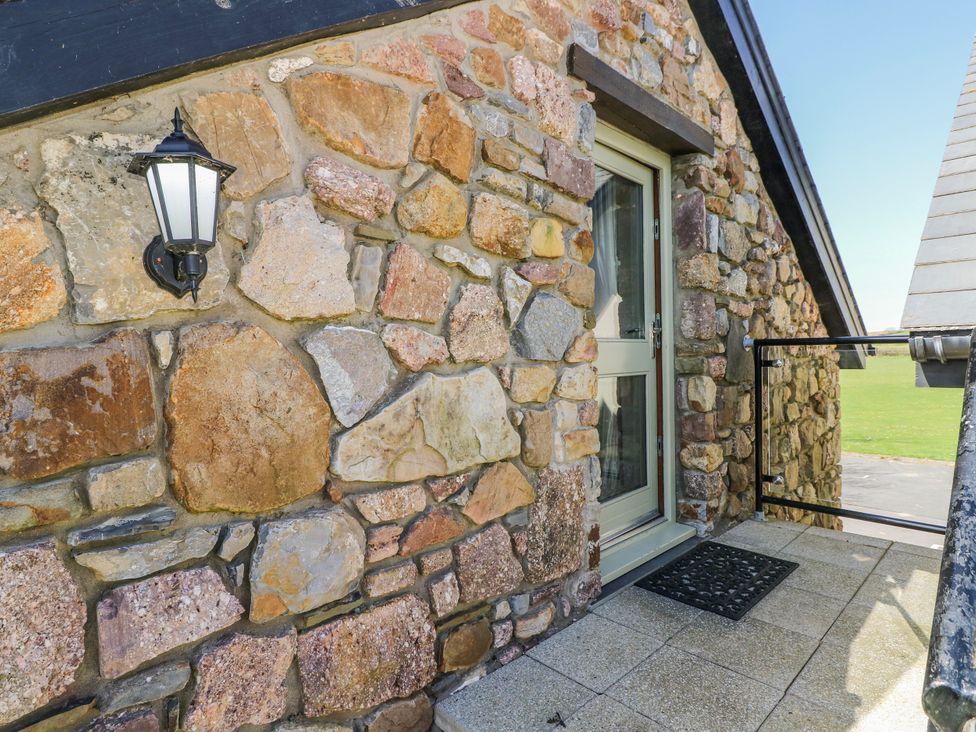 An exterior view showing a stone wall and a door at Willow Apartment in Oldwalls, Llanrhidian, Gower