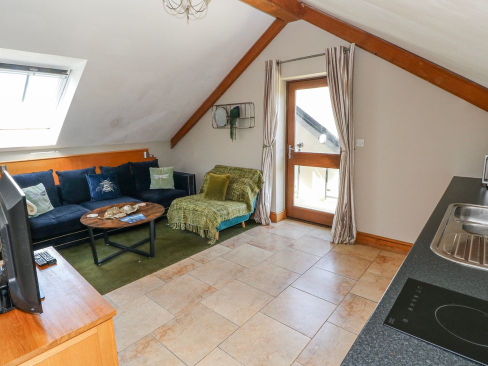 A living room with a sofa and coffee table at Willow Apartment in Oldwalls, Llanrhidian, Gower