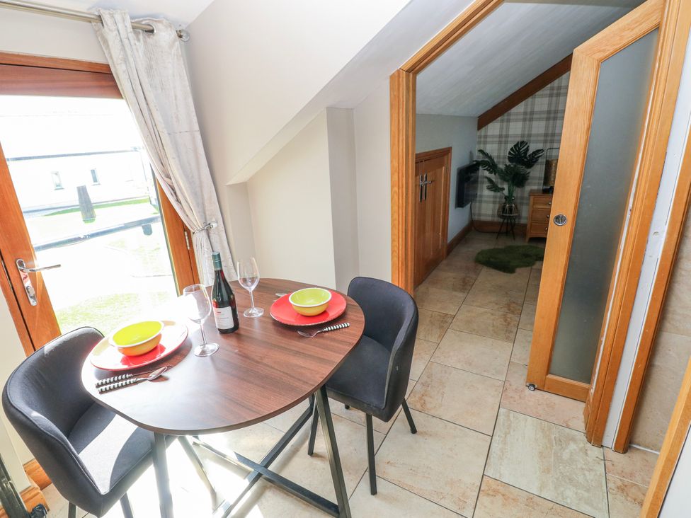 A dining area with a table and chairs at Willow Apartment, Oldwalls, Llanrhidian, Gower