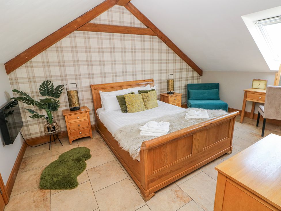 A bedroom with a bed and nightstands at Willow Apartment Oldwalls, Llanrhidian, Gower