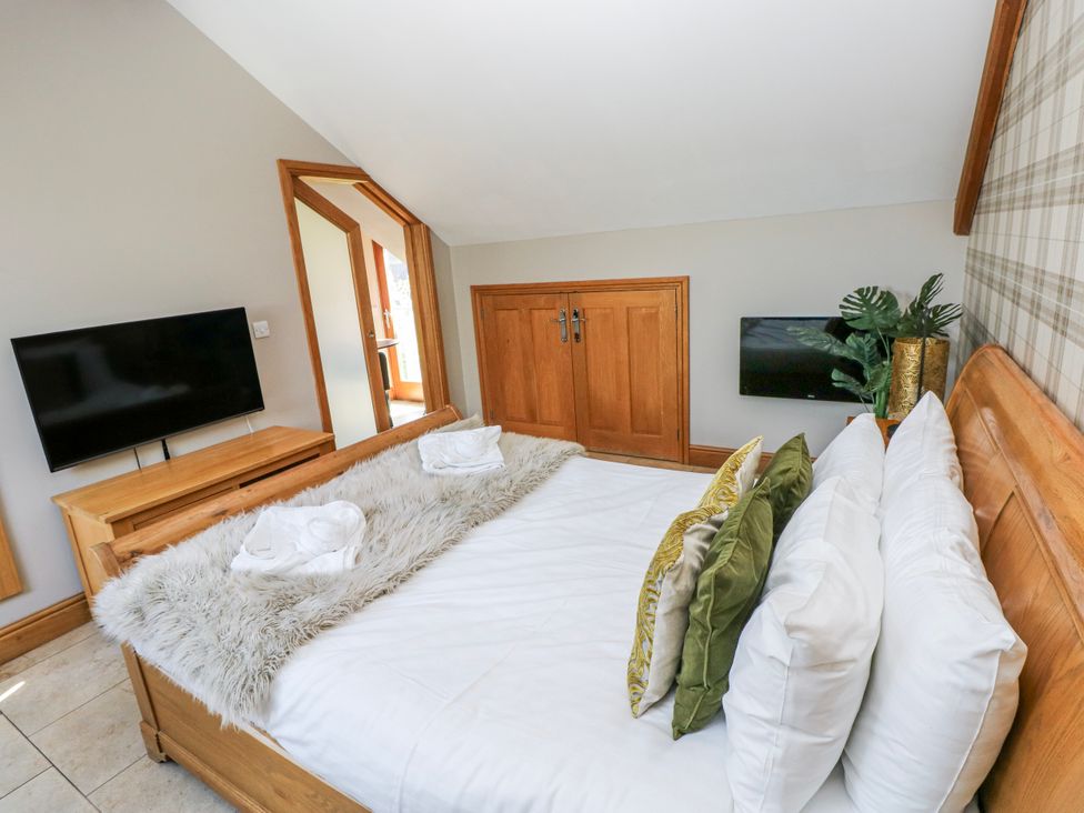 A bedroom with a bed and television at Willow Apartment, Oldwalls, Llanrhidian, Gower