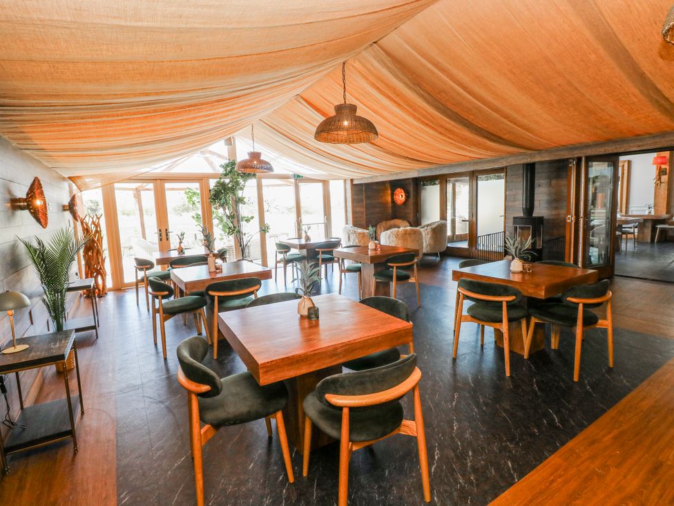 A dining room with tables and chairs at Willow Apartment, Oldwalls, Llanrhidian, Gower