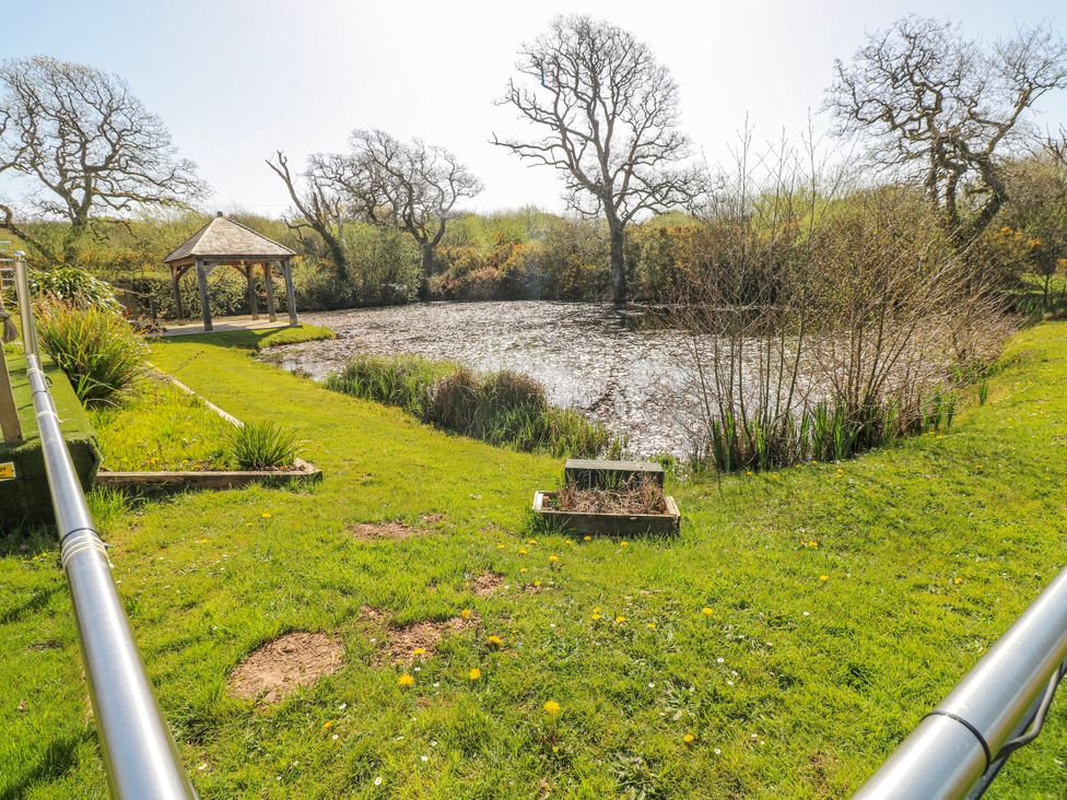 A garden with a pond and pavilion at Willow Apartment Oldwalls, Llanrhidian, Gower