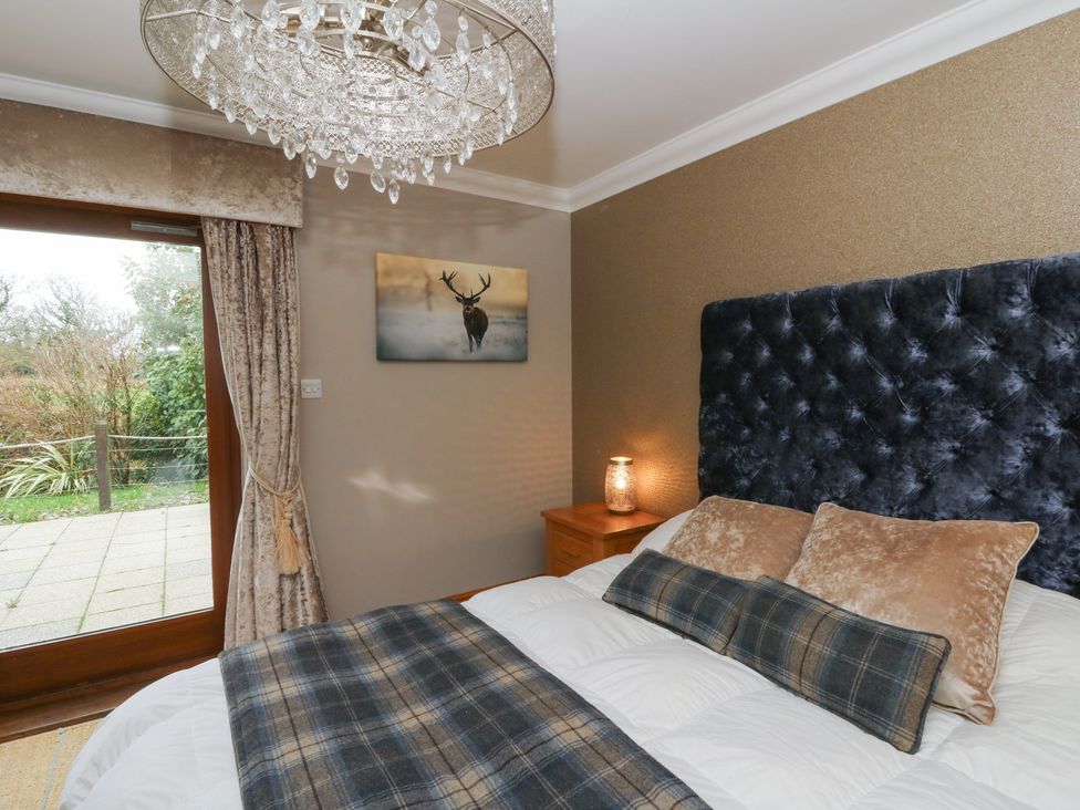 A bedroom with a bed and a bedside table at Ivy Cottage in Swansea