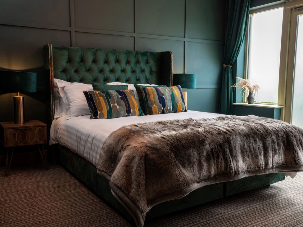 A bedroom with a bed and side table at Ivy Cottage Oldwalls near Reynoldston