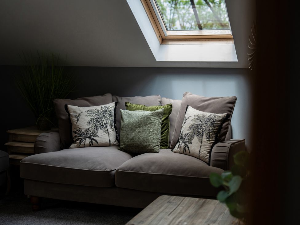 A sofa with cushions and a skylight at Ivy Cottage Oldwalls near Reynoldston