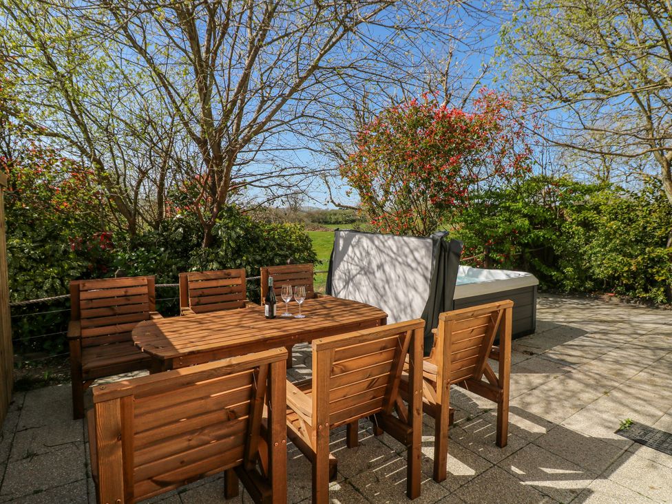 An outdoor area with a wooden table and chairs at Ivy Cottage Oldwalls, Llanrhidian, Gower