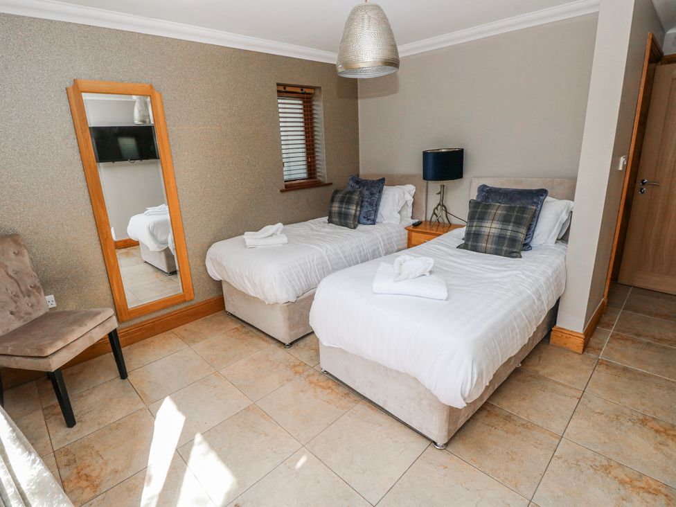 A bedroom with two single beds and a mirror at Ivy Cottage in Oldwalls, Llanrhidian, Gower
