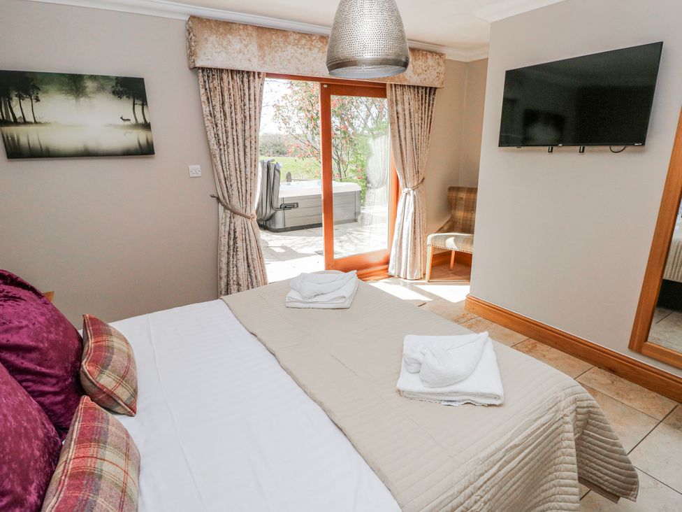 A bedroom with a bed and sliding door at Ivy Cottage in Oldwalls, Llanrhidian, Gower
