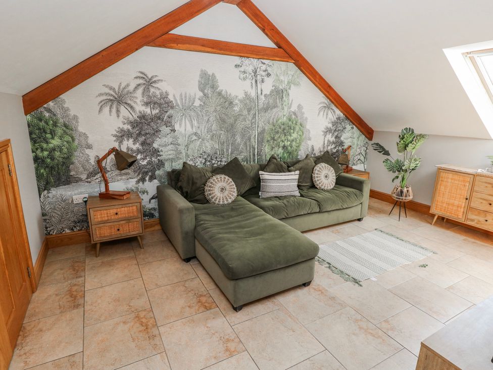 A living room with a sofa and lamp at Ivy Cottage in Oldwalls, Llanrhidian, Gower